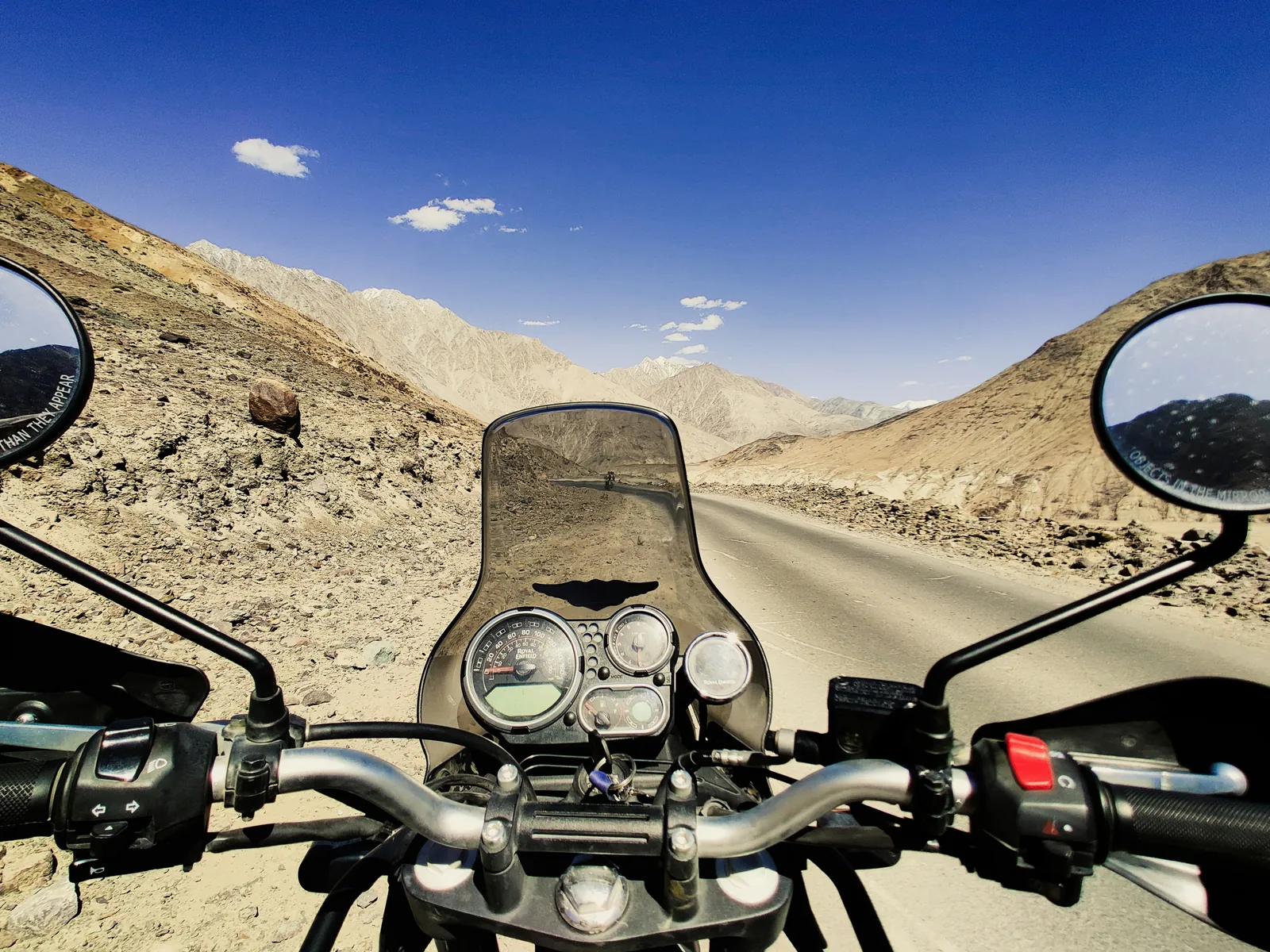 Bikers riding Royal Enfield motorcycles on Leh Ladakh mountain roads